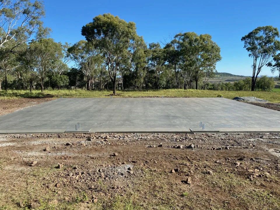 Concrete slab with open ground around its edges.