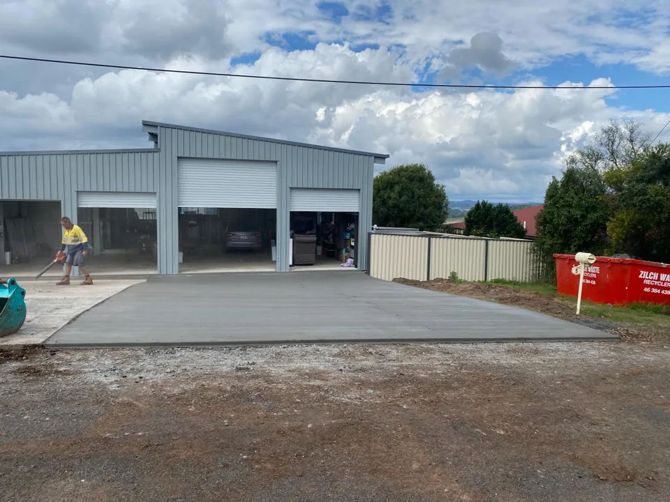 Concrete apron in front of a building with roller doors.