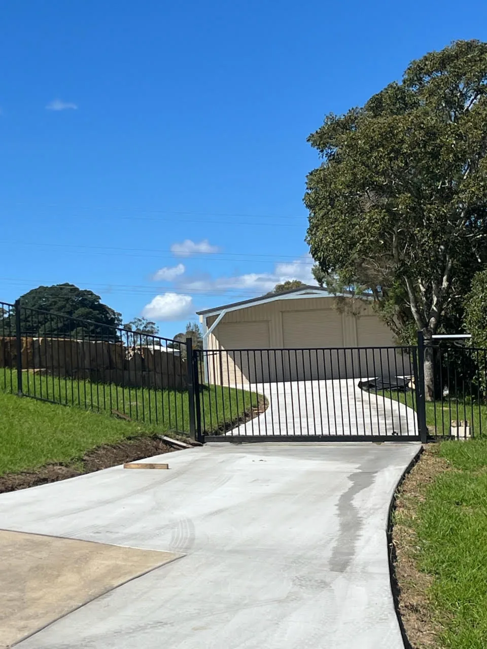 Concrete access area passing through a gate towards a shed.